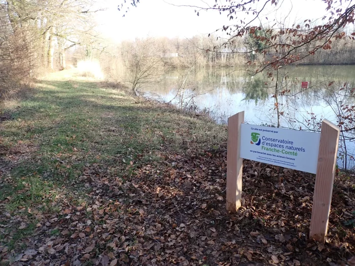 panneau de site du Conservatoire d'espaces naturels de Franche-Comté au bord d'un étang
